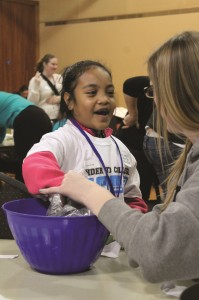 This Kent School District student participates in a fun learning activity led by a PLU student.  She is part of the Kinder to College program that visited campus.  