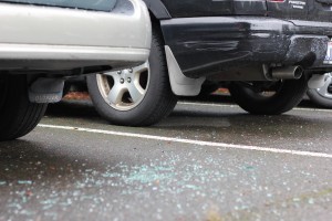 Broken glass lays on the ground in Yakima Lot on Friday afternoon after a series of early-morning car burglaries.