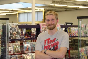 Kevin Knodell, Nerdy Stuffs' community outreach coordinator, stands in front of rows of comic books. Photo by Jessica Trondsen.