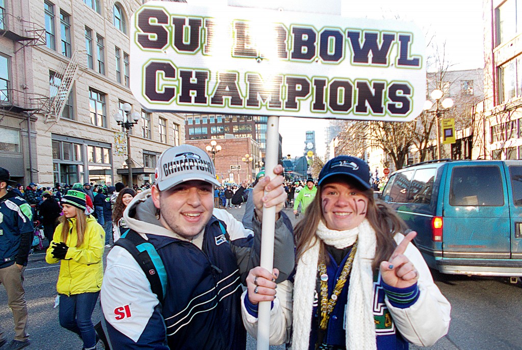 Junior Alex Gallo and first-year Kiera Stevens hold a sign at the Seahawk parade in Seattle on Feb. 5. 2014. Gallo's professor dropped him from his class for attending the parade without making prior arrangements.
