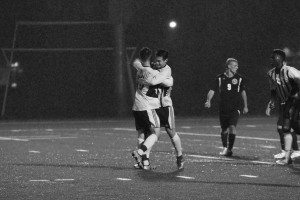 PHOTO BY BAILEY PLUMB: Sophomore Eddie Na (9) hugs senior Troy-Mikal Oliger (10) after scoring a penalty kick. Na was second in the league with 12 goals.